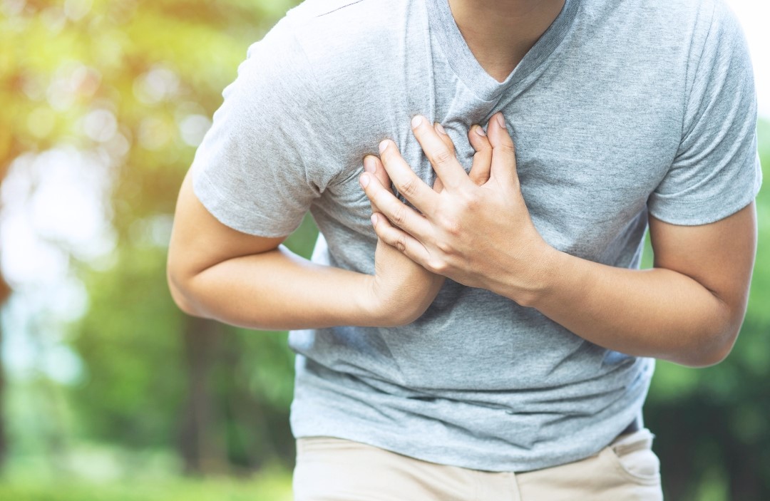 man having chest pain at the park